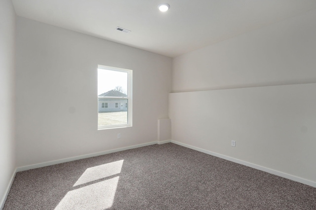 empty room featuring carpet, visible vents, and baseboards