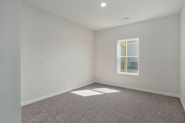 unfurnished room with baseboards, visible vents, and carpet floors