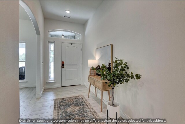5202 S April Ct, Battlefield, MO 65619 - entrance foyer featuring arched walkways, visible vents, light wood-type flooring, and baseboards