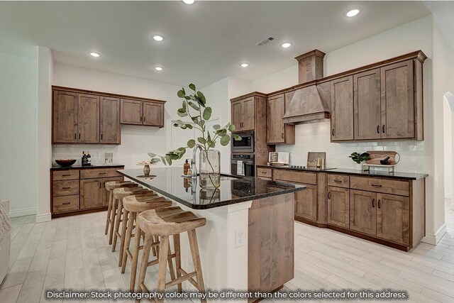 5202 S April Ct, Battlefield, MO 65619 - kitchen featuring visible vents, a kitchen island with sink, a sink, black appliances, and tasteful backsplash