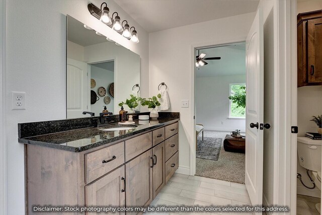 5202 S April Ct, Battlefield, MO 65619 - bathroom with baseboards, toilet, vanity, and a ceiling fan