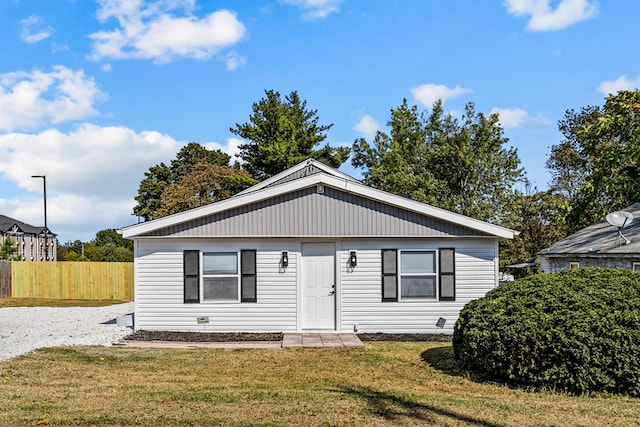 bungalow-style house with a front lawn and fence