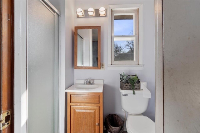 full bath with a shower with door, toilet, and vanity