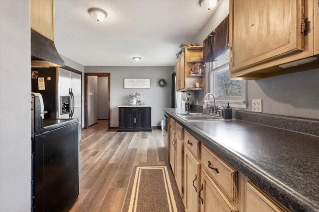 kitchen with dark countertops, open shelves, stainless steel refrigerator with ice dispenser, light wood-style floors, and a sink