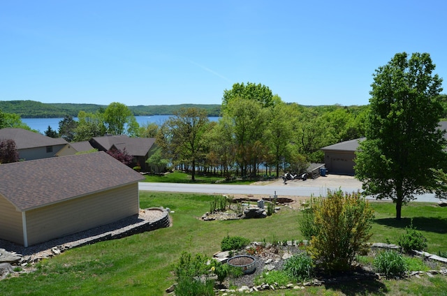 view of yard featuring a water view and a garage