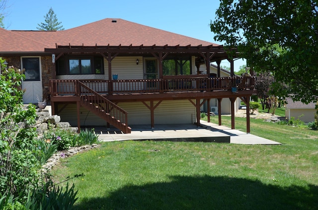 rear view of house featuring a wooden deck, a pergola, a patio area, and roof with shingles