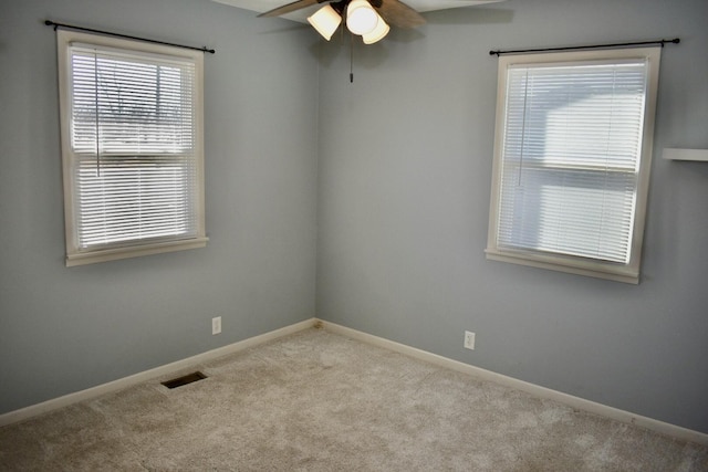 spare room featuring baseboards, visible vents, carpet floors, and ceiling fan