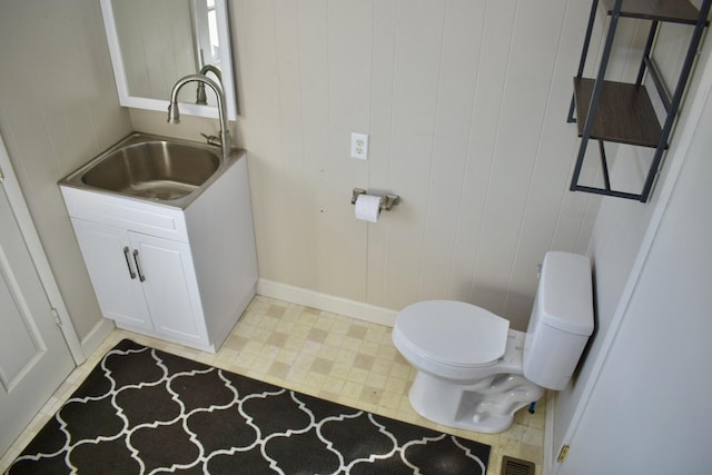 half bathroom featuring tile patterned floors, visible vents, toilet, and vanity