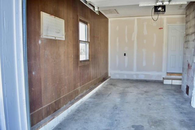 garage featuring wooden walls and a garage door opener