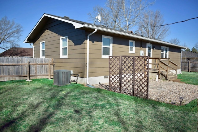 back of house featuring crawl space, central air condition unit, a lawn, and fence