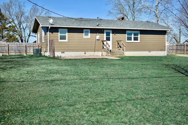 back of property featuring crawl space, a fenced backyard, a yard, and central AC