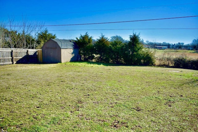 view of yard with a storage unit, an outdoor structure, and fence