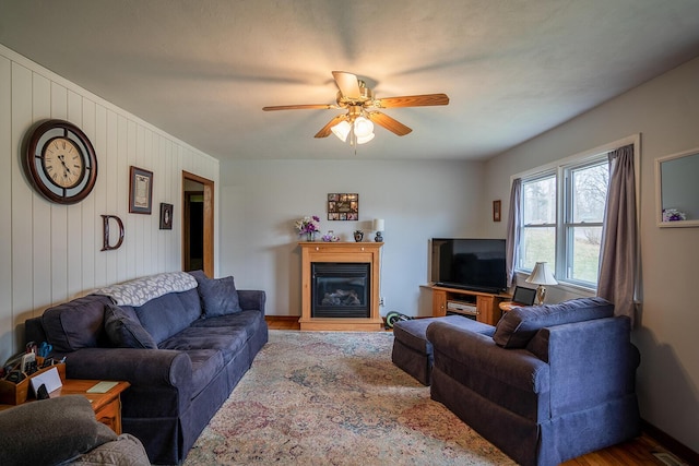 2457 County Road 1770, West Plains, MO 65775 - living room featuring wood finished floors, ceiling fan, a glass covered fireplace, baseboards, and visible vents
