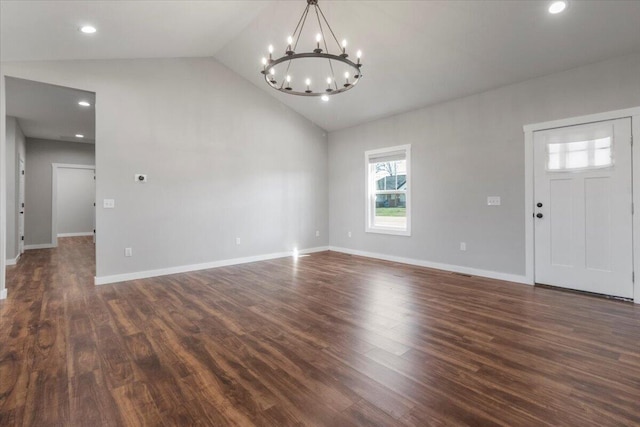 interior space with baseboards, dark wood finished floors, recessed lighting, vaulted ceiling, and a chandelier