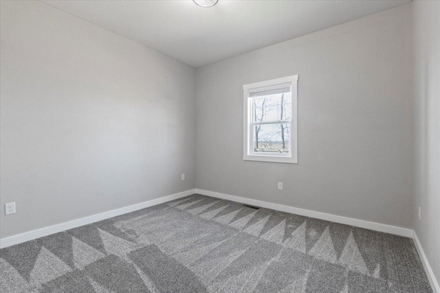 empty room with visible vents, carpet, and baseboards