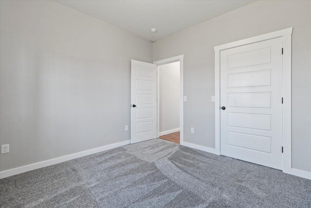 unfurnished bedroom featuring carpet and baseboards