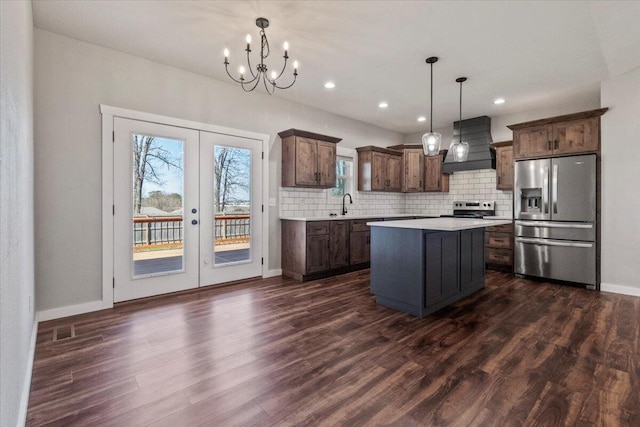 kitchen featuring premium range hood, tasteful backsplash, french doors, appliances with stainless steel finishes, and light countertops