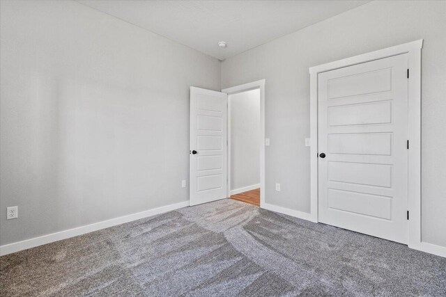 unfurnished bedroom with baseboards and carpet flooring