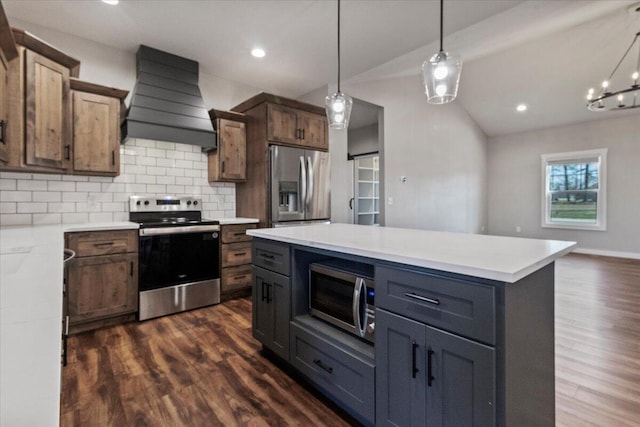 kitchen with decorative backsplash, dark wood-type flooring, premium range hood, and appliances with stainless steel finishes