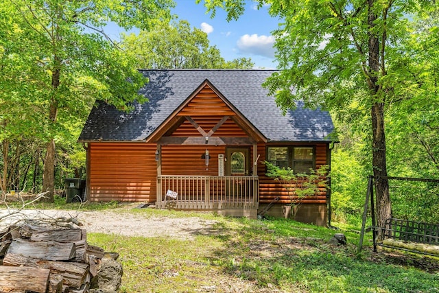 view of front of house with log veneer siding, a porch, and roof with shingles