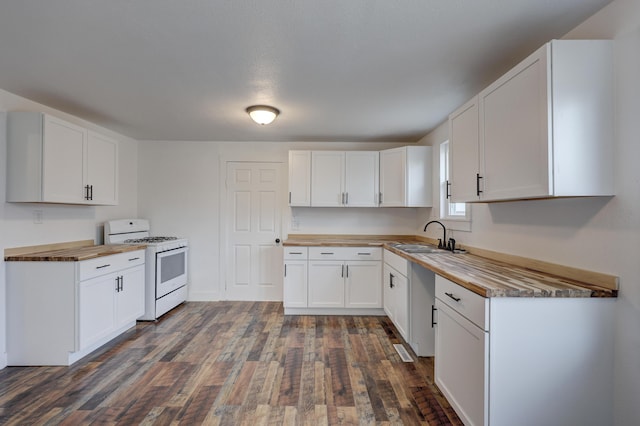 kitchen with a sink, white range with gas stovetop, dark wood finished floors, and butcher block counters