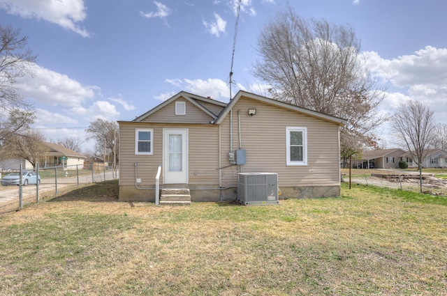 back of house with entry steps, a yard, fence, and central AC