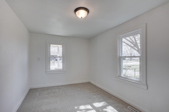 carpeted spare room with baseboards and visible vents