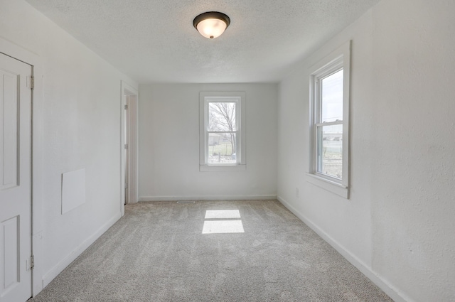 unfurnished room with baseboards, a textured ceiling, and carpet flooring