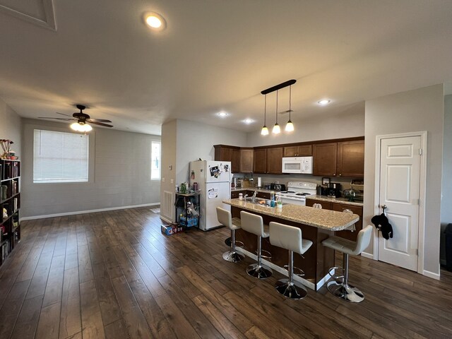 610 N Center St, Willow Springs, MO 65793 - kitchen with white appliances, a breakfast bar area, decorative light fixtures, and dark wood-type flooring