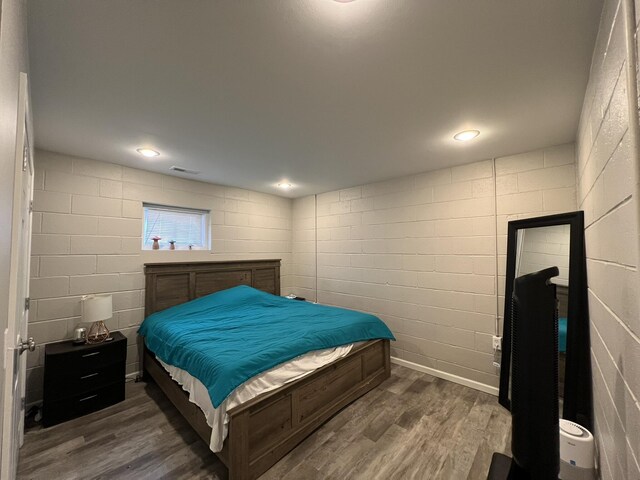 610 N Center St, Willow Springs, MO 65793 - bedroom featuring dark wood finished floors, visible vents, recessed lighting, and concrete block wall