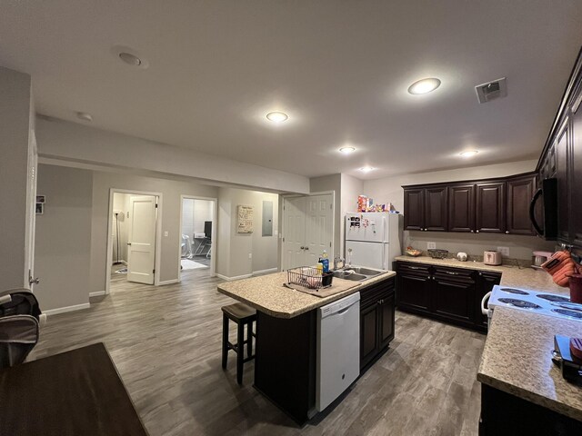 610 N Center St, Willow Springs, MO 65793 - kitchen with visible vents, light countertops, light wood-style floors, white appliances, and a kitchen island with sink