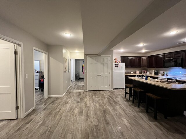 610 N Center St, Willow Springs, MO 65793 - kitchen with light wood-type flooring, a kitchen breakfast bar, range with electric stovetop, freestanding refrigerator, and black microwave