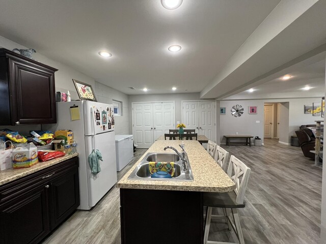610 N Center St, Willow Springs, MO 65793 - kitchen with a breakfast bar, light countertops, light wood-style flooring, freestanding refrigerator, and a sink