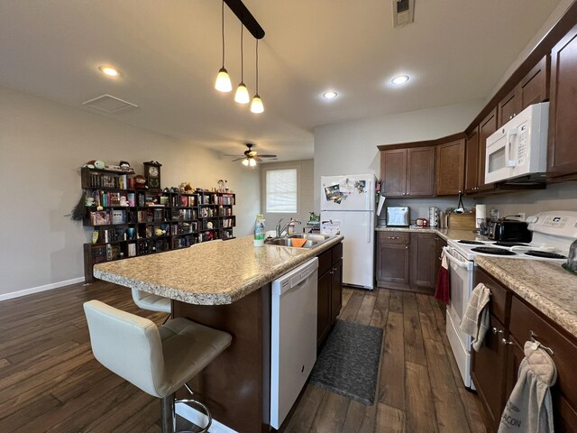 610 N Center St, Willow Springs, MO 65793 - kitchen with white appliances, visible vents, an island with sink, dark wood-style flooring, and a sink