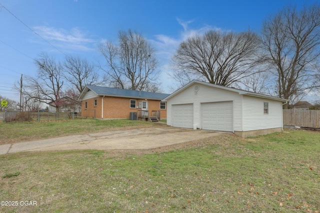 exterior space featuring an outbuilding, a front lawn, central AC, fence, and brick siding