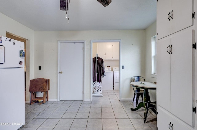 interior space with light tile patterned floors, baseboards, and independent washer and dryer