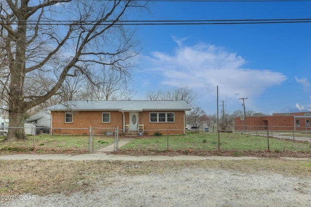 view of front of property with a gate, brick siding, a fenced front yard, and metal roof