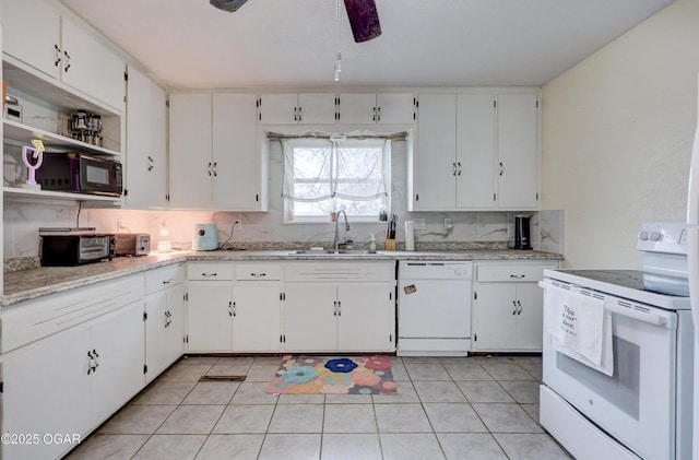 kitchen with light tile patterned floors, white cabinets, white appliances, and a sink