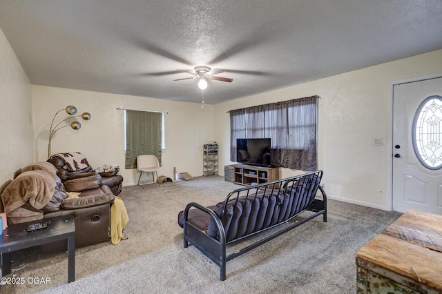 living area featuring a ceiling fan, carpet, baseboards, and a textured ceiling