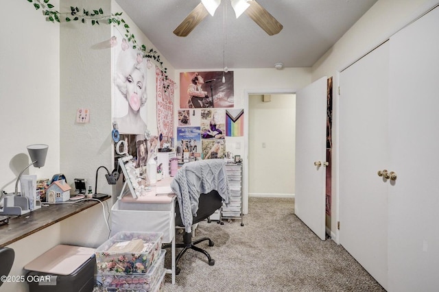 home office with carpet and a ceiling fan