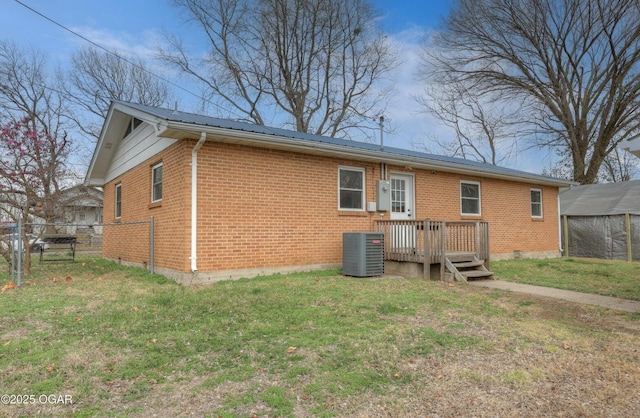 back of house with brick siding, cooling unit, a yard, and fence