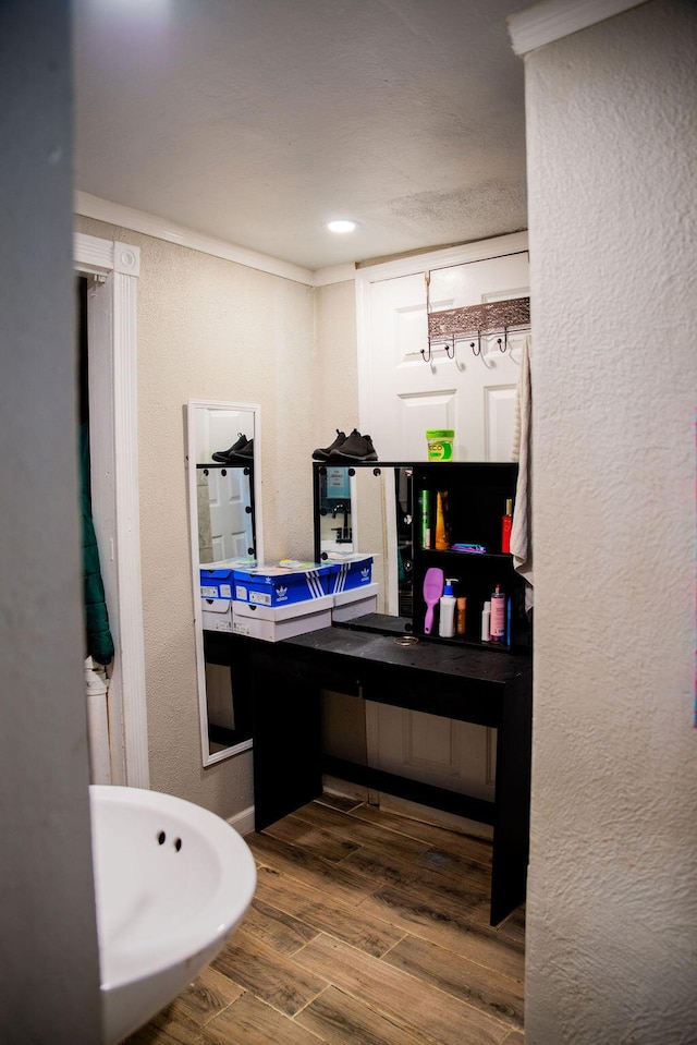 bathroom featuring vanity, a textured wall, and wood finished floors