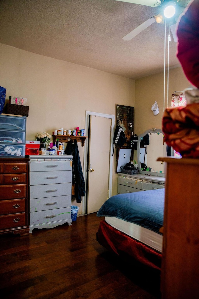 bedroom featuring a textured ceiling, dark wood-type flooring, and ceiling fan
