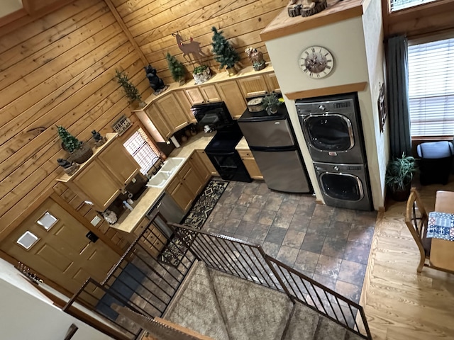 215 Oakridge Rd, Branson, MO 65616 - washroom featuring estacked washer and dryer, plenty of natural light, and wood walls