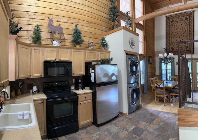 215 Oakridge Rd, Branson, MO 65616 - kitchen with black appliances, estacked washer and dryer, a towering ceiling, a sink, and light countertops