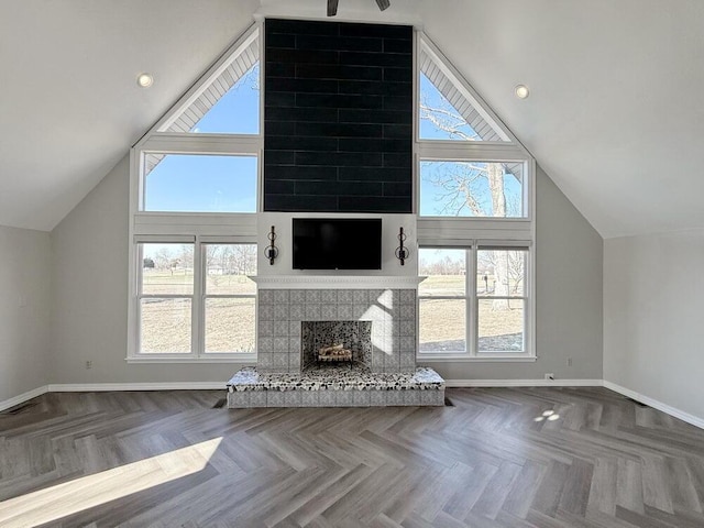 3100 E 354th Rd, El Dorado Springs, MO 64744 - unfurnished living room featuring lofted ceiling, baseboards, a fireplace with raised hearth, and plenty of natural light