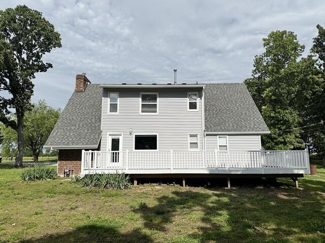 3100 E 354th Rd, El Dorado Springs, MO 64744 - rear view of house with roof with shingles, a chimney, a deck, and a lawn