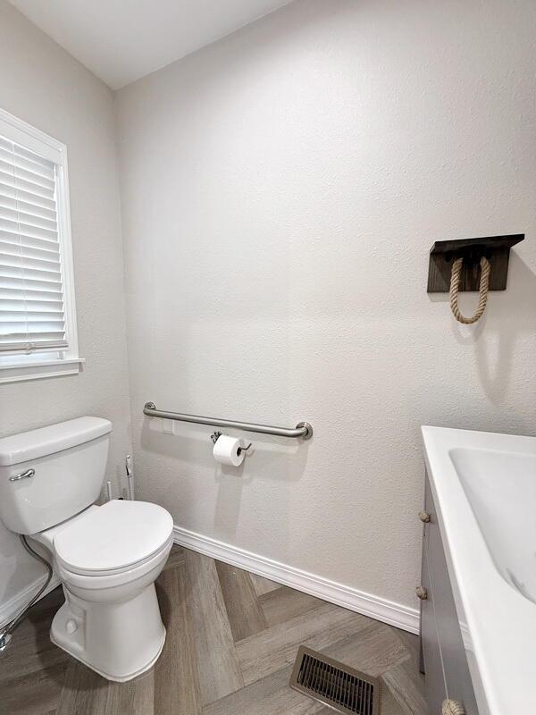 3100 E 354th Rd, El Dorado Springs, MO 64744 - bathroom with vanity, toilet, baseboards, and wood finished floors