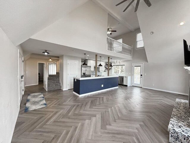 3100 E 354th Rd, El Dorado Springs, MO 64744 - unfurnished living room with ceiling fan, high vaulted ceiling, stairway, baseboards, and a fireplace