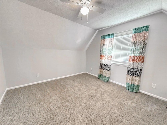 3100 E 354th Rd, El Dorado Springs, MO 64744 - additional living space with vaulted ceiling, carpet flooring, a ceiling fan, baseboards, and a textured ceiling